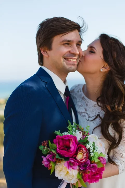 Bride kissing groom on the cheek