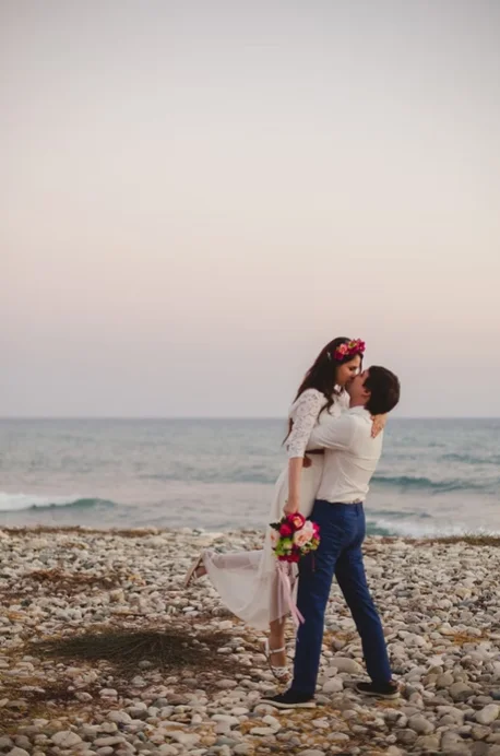 Newlywed couple kiss on the beach