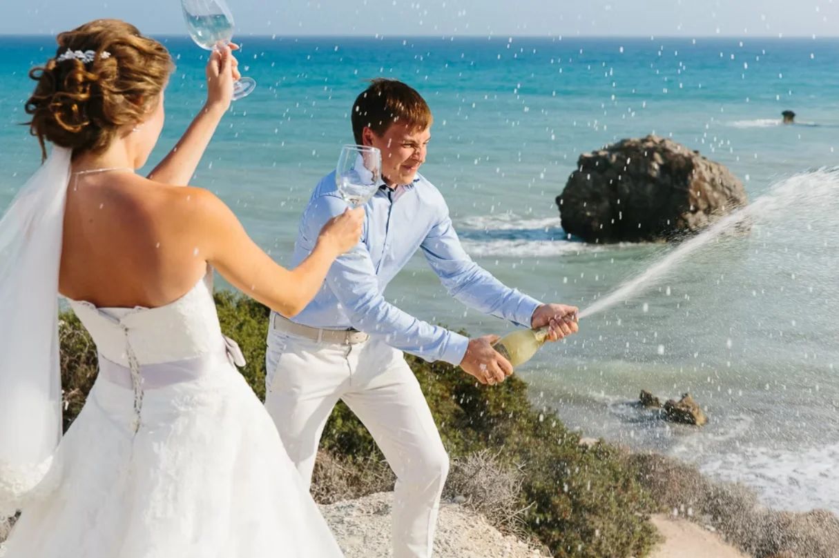 Opening champagne with sea in the background