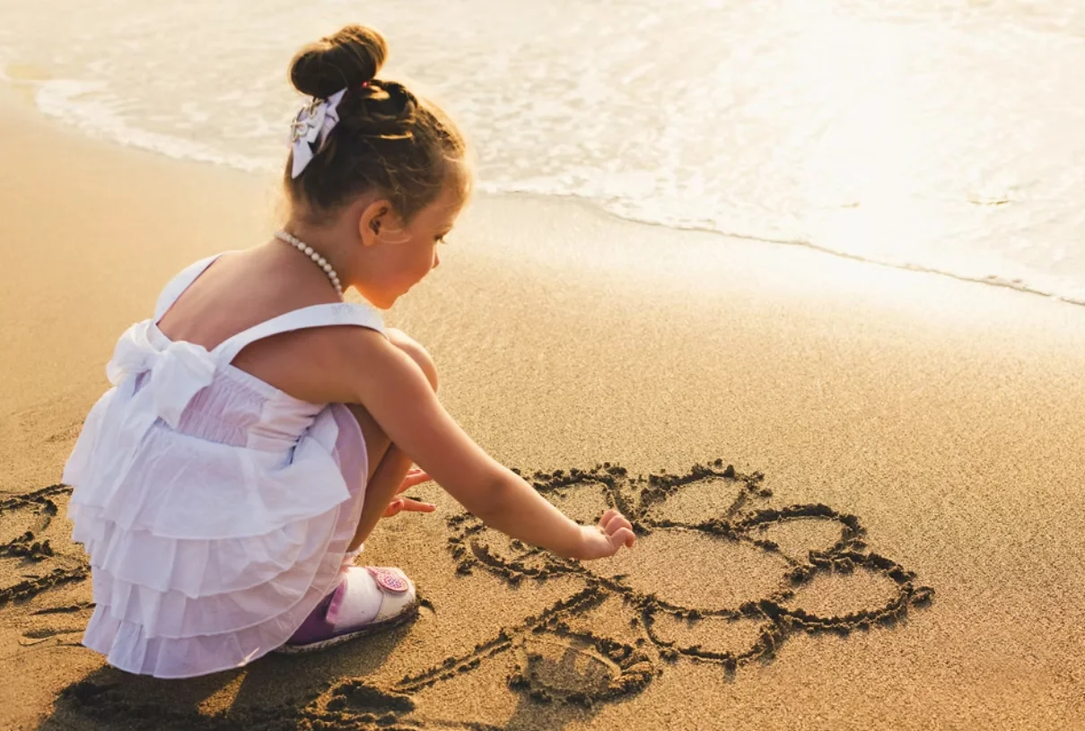 Girl drawing in sand