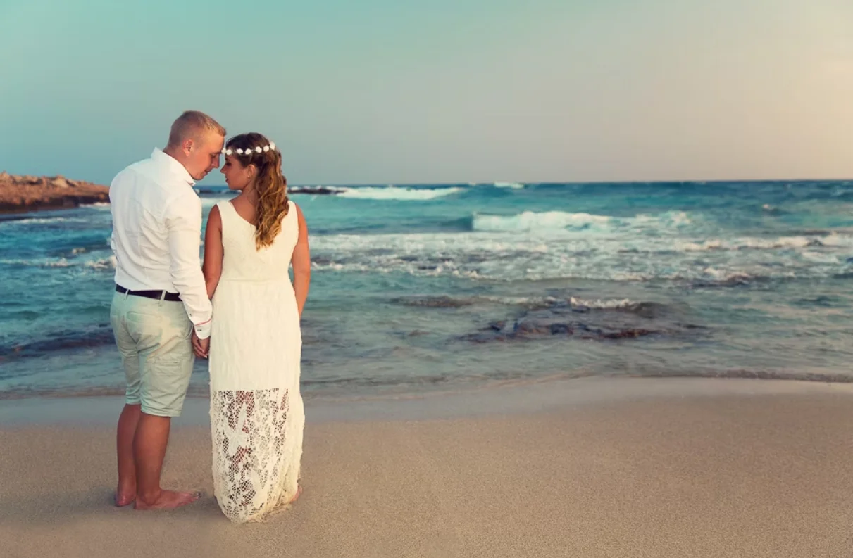 Couple holding hands and looking at each other at the beach