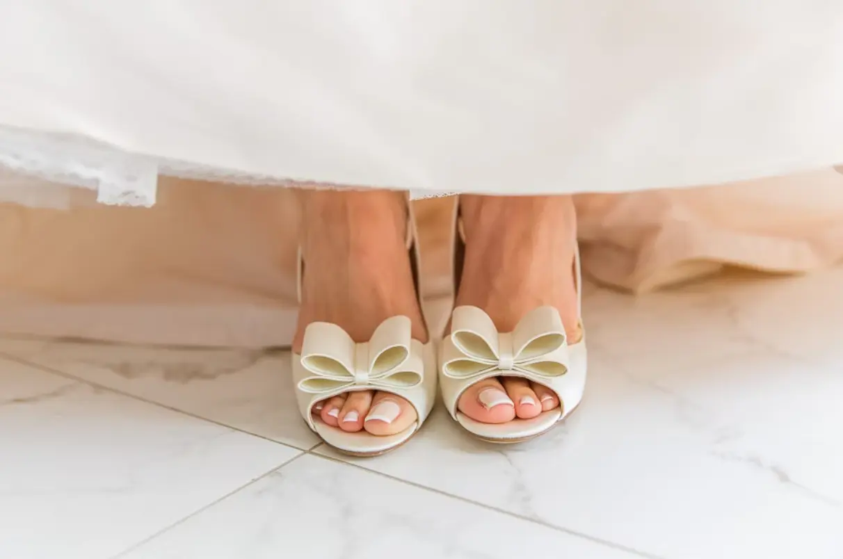 Brides feet wearing white shoes
