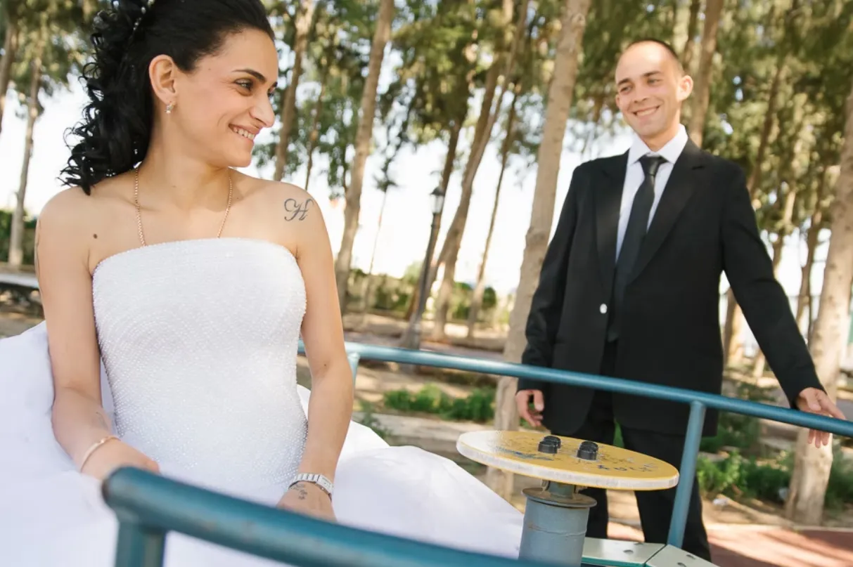 Bride and groom sharing a relaxed moment together, the bride is wearing a white dress and groom in a dark suit