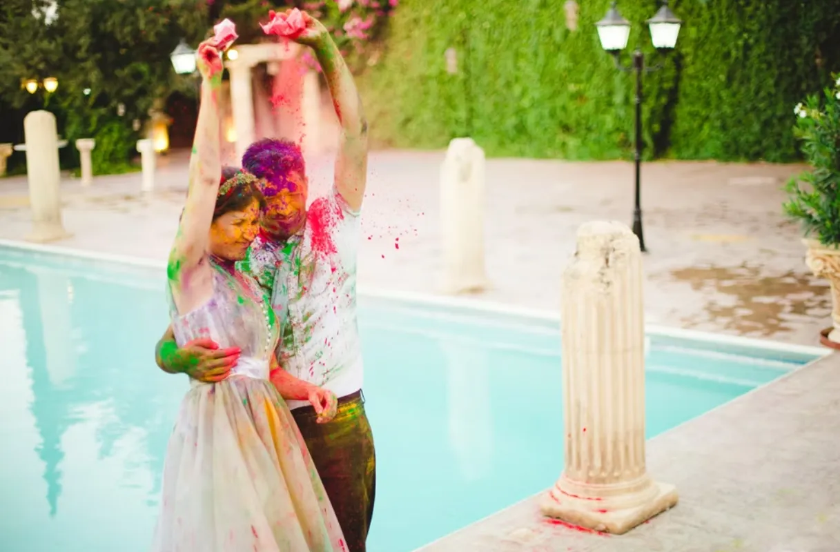 Bride and groom share joyful moment covered in colourful powder