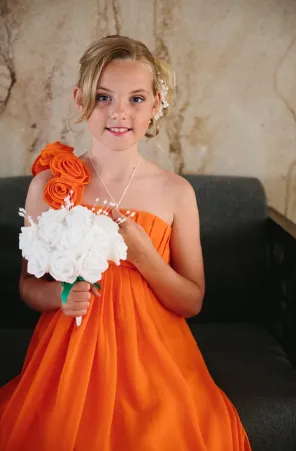 Young bridemaid holding white bouquet of flowers