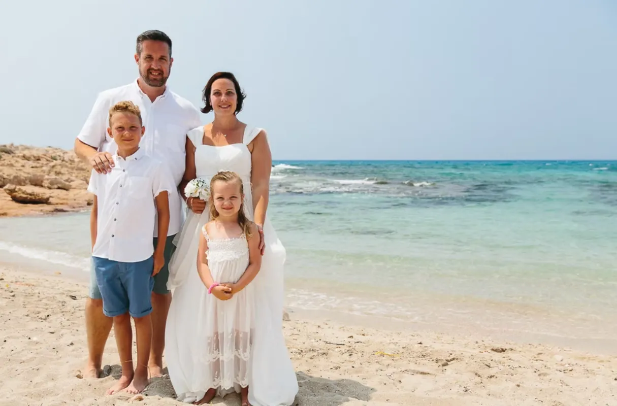 Family portait at the beach with the sea in the background