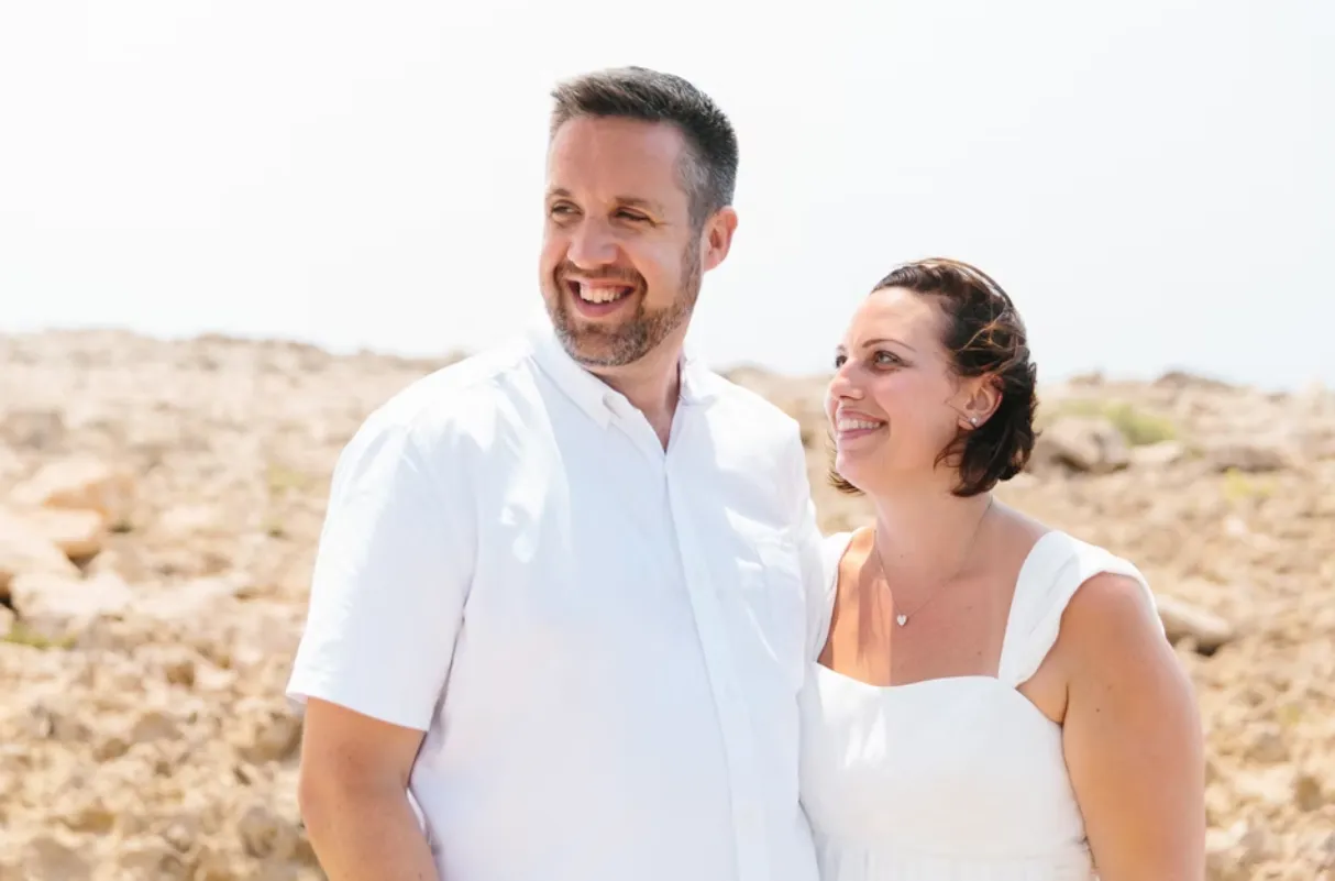 Couple both wearing white and smiling together