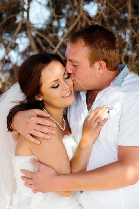 Groom kissing happy bride